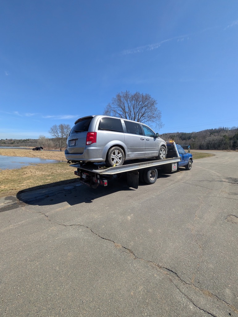 Silver Dodge Grand Caravan minivan transport by lake
